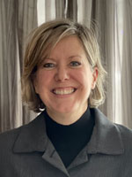 Middle aged woman wearing a grey suit.