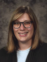 Middle aged woman wearing a dark suit.