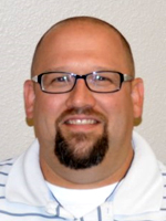 Middle aged man wearing a light colored shirt.