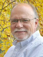Middle aged man wearing a light colored shirt.