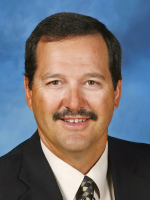 Middle aged man wearing a dark suit.