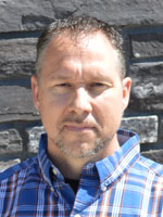 Middle aged man wearing a blue shirt.