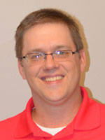 Middle aged man wearing a red shirt.
