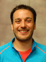 Younger man wearing a blue shirt with orange trim.
