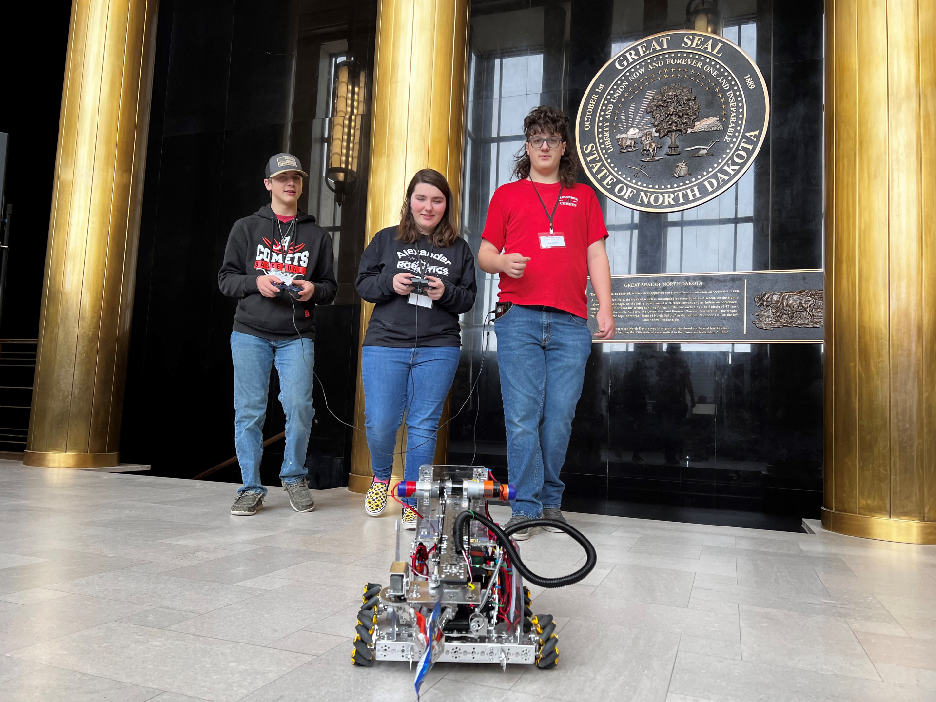 Alexander Public School students Garrett, Peiten, and Austin display their hand-built robot.