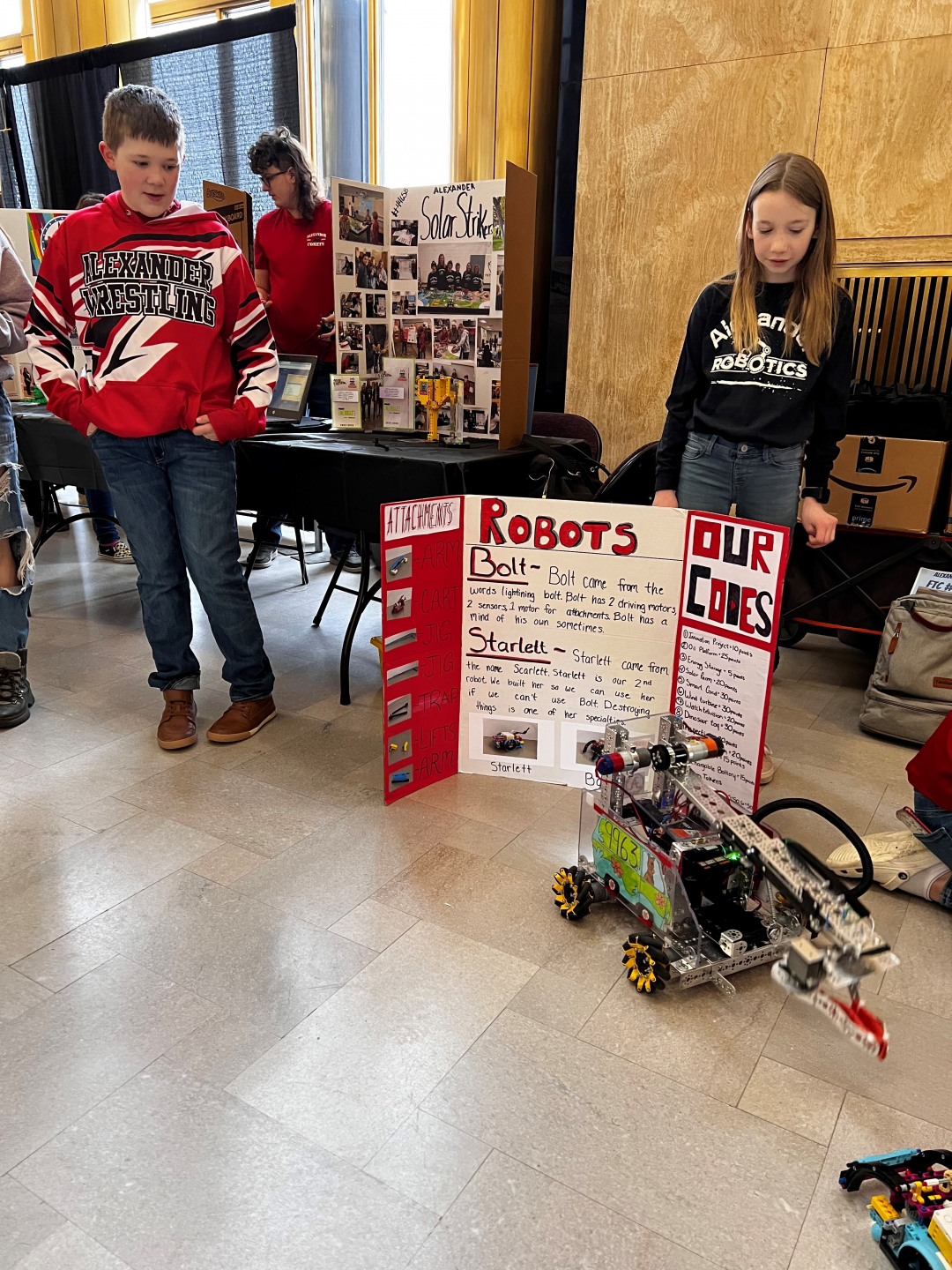 Alexander public school students with one of their robots as part of their The Future of Technology &  Cyber Security is NOW presentation